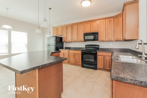 a kitchen with wooden cabinets and black appliances
