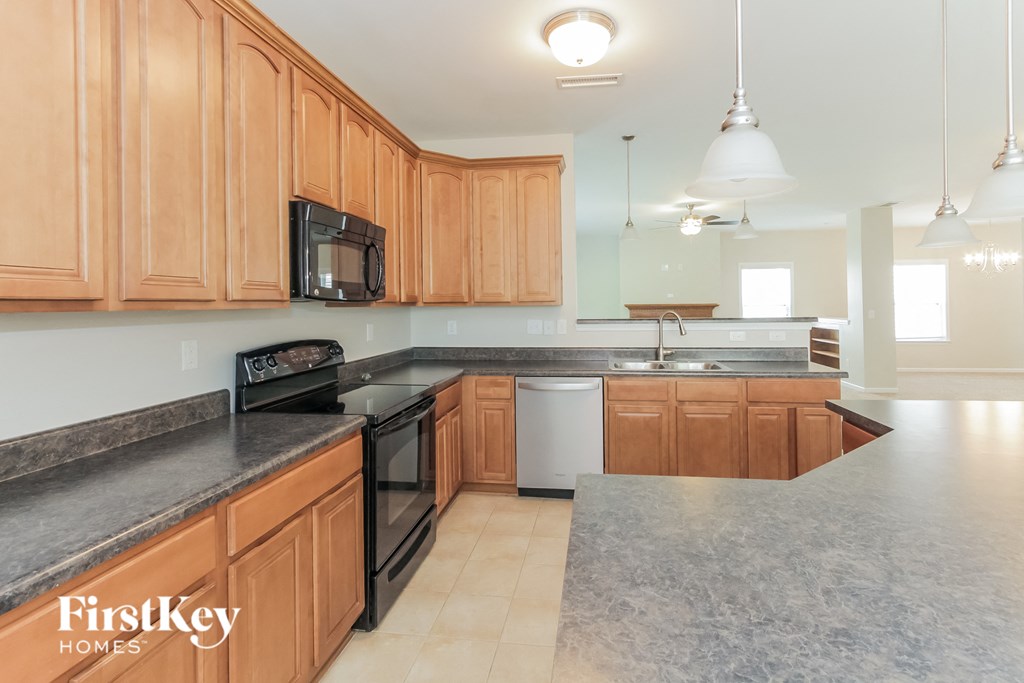 a kitchen with wood cabinets and black counter tops and a black and white counter top