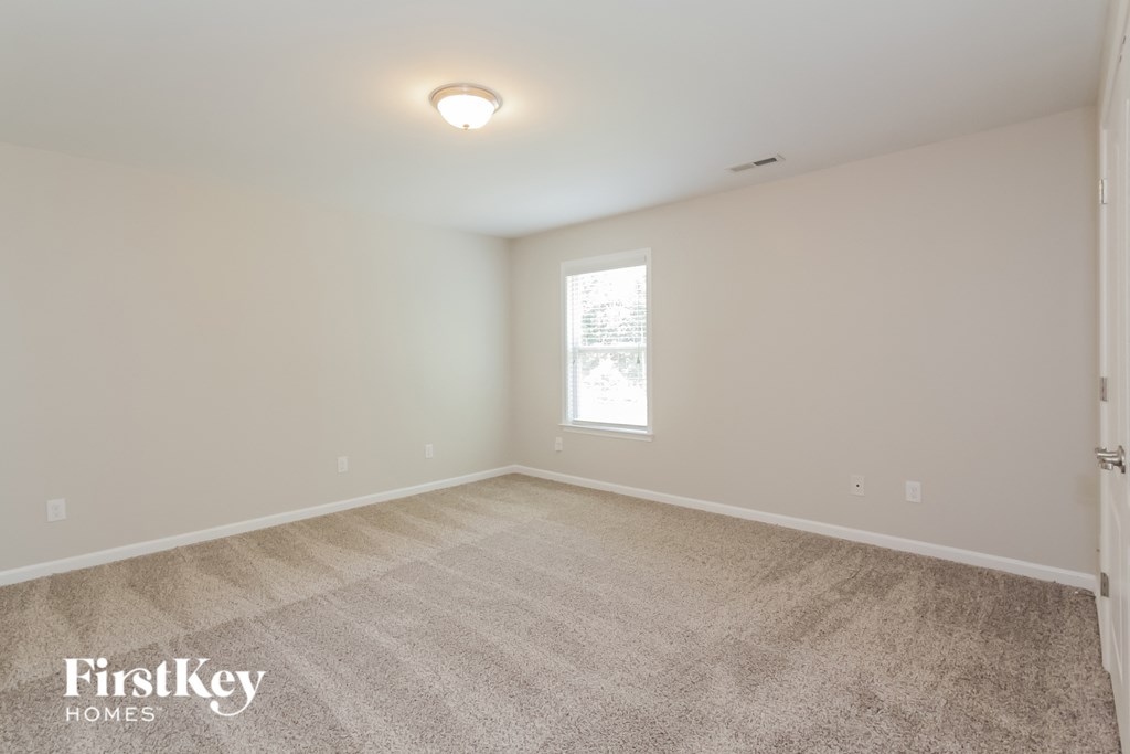 a bedroom with a carpeted floor and a window