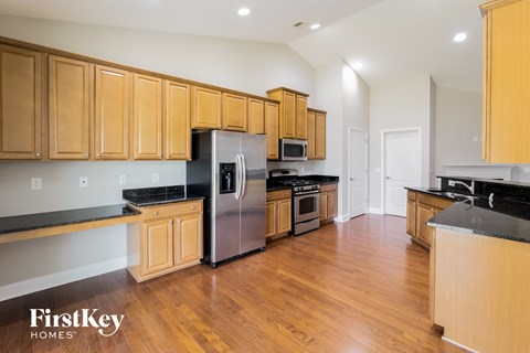 A kitchen with wooden cabinets and a stainless steel refrigerator.