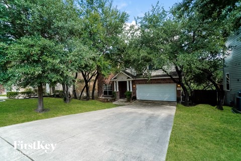 a house with a driveway and trees in front of it