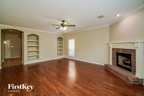 a living room with a fireplace and a ceiling fan