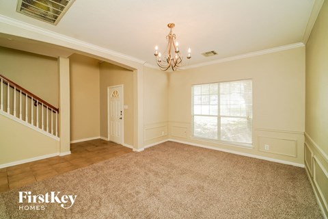 a dining room with a chandelier and a window