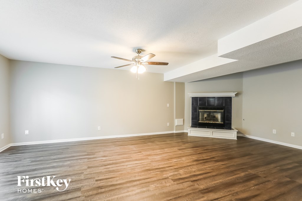 a living room with a fireplace and a ceiling fan