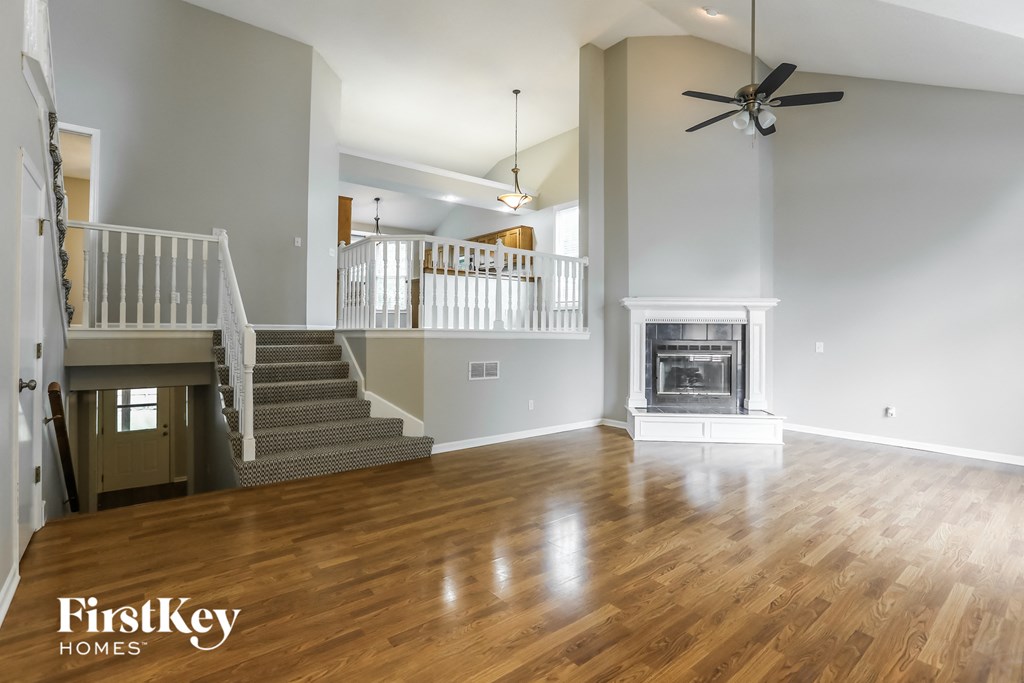 an empty living room with a fireplace and stairs