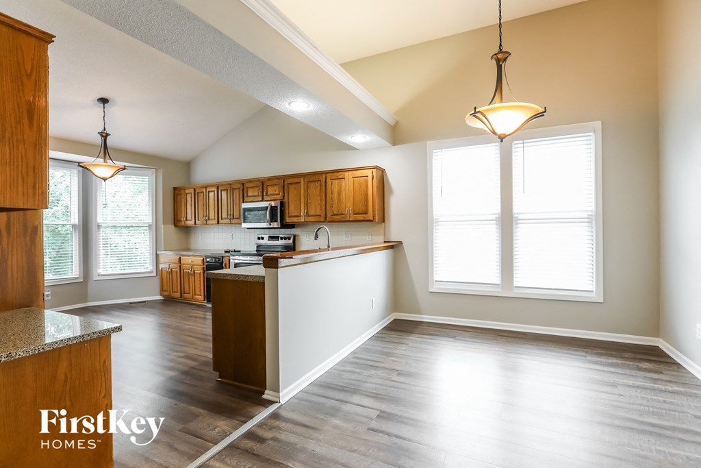 an empty kitchen with wooden cabinets and a white counter top
