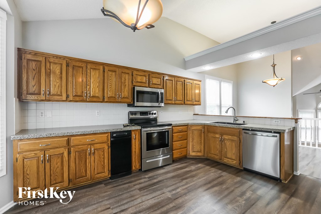 a kitchen with wooden cabinets and stainless steel appliances