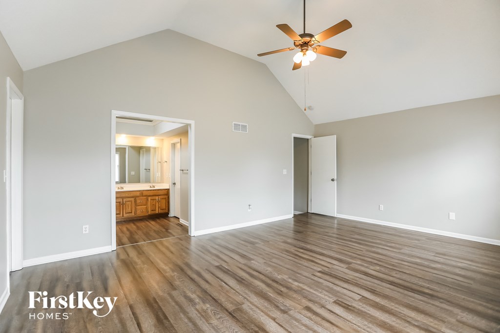 an empty living room with wood flooring and a ceiling fan