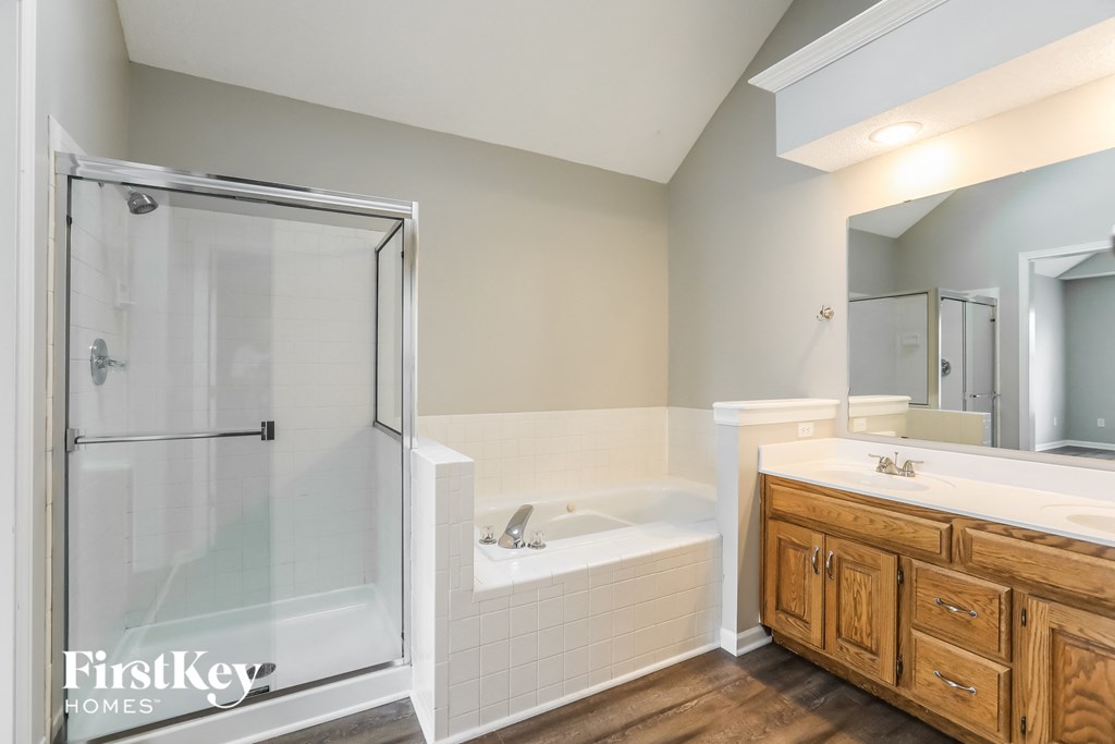 a bathroom with a tub and a shower and a sink