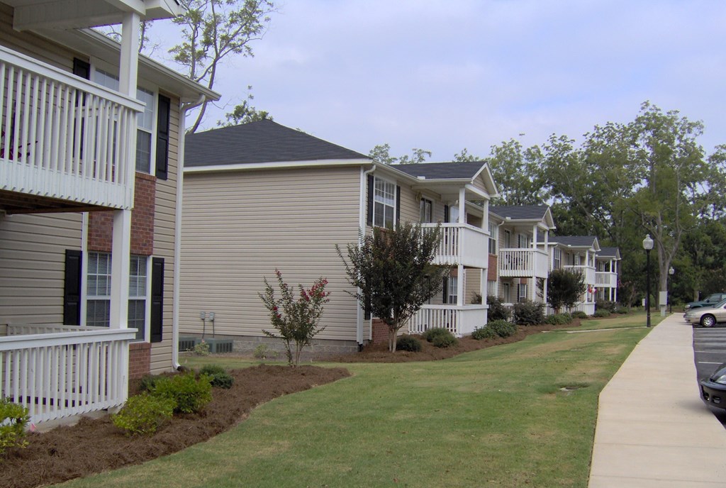 a row of condominiums on the side of a sidewalk
