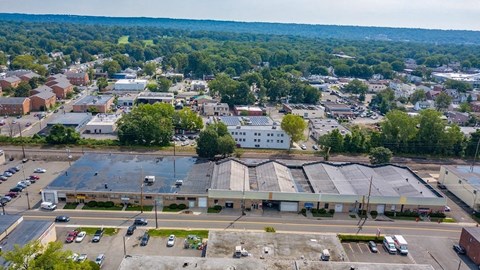 A large industrial building with a parking lot in front of it.