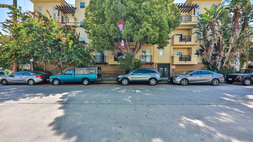 a row of cars parked in front of an apartment building