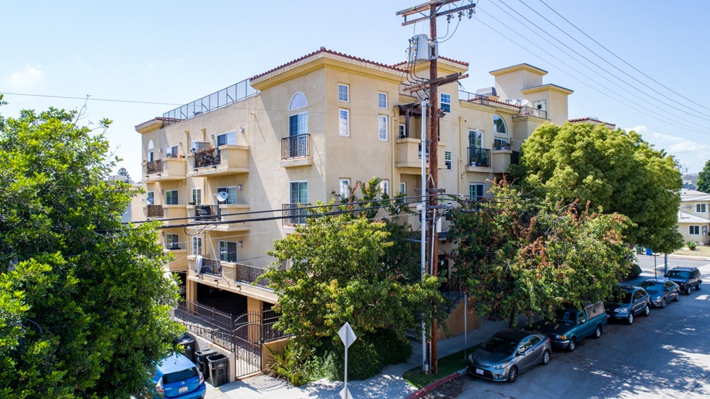 an apartment building with cars parked in front of it