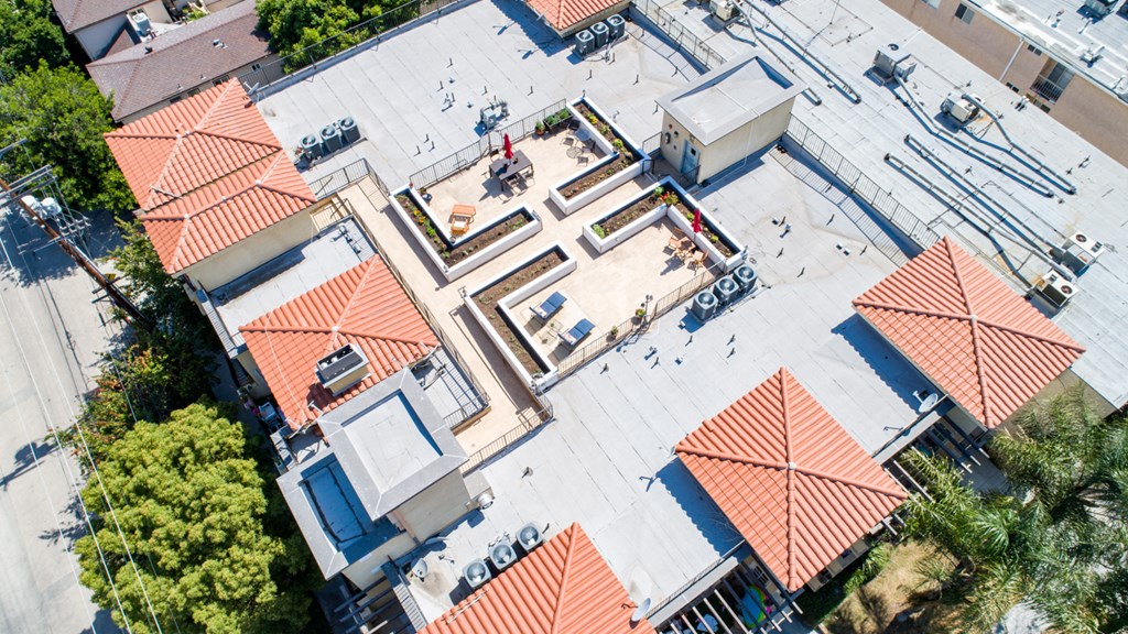 an aerial view of a building with red rooftops and people walking around