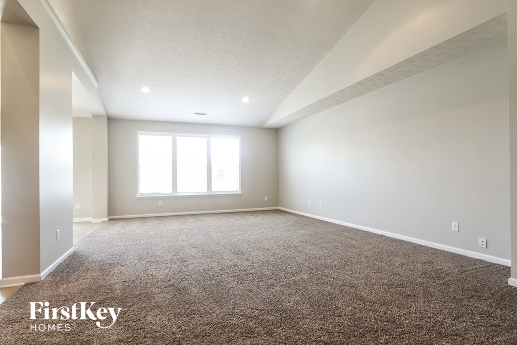 an empty room with carpet and a window