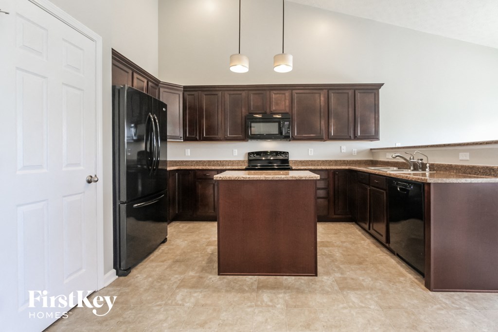 a kitchen with black appliances and dark wood cabinets