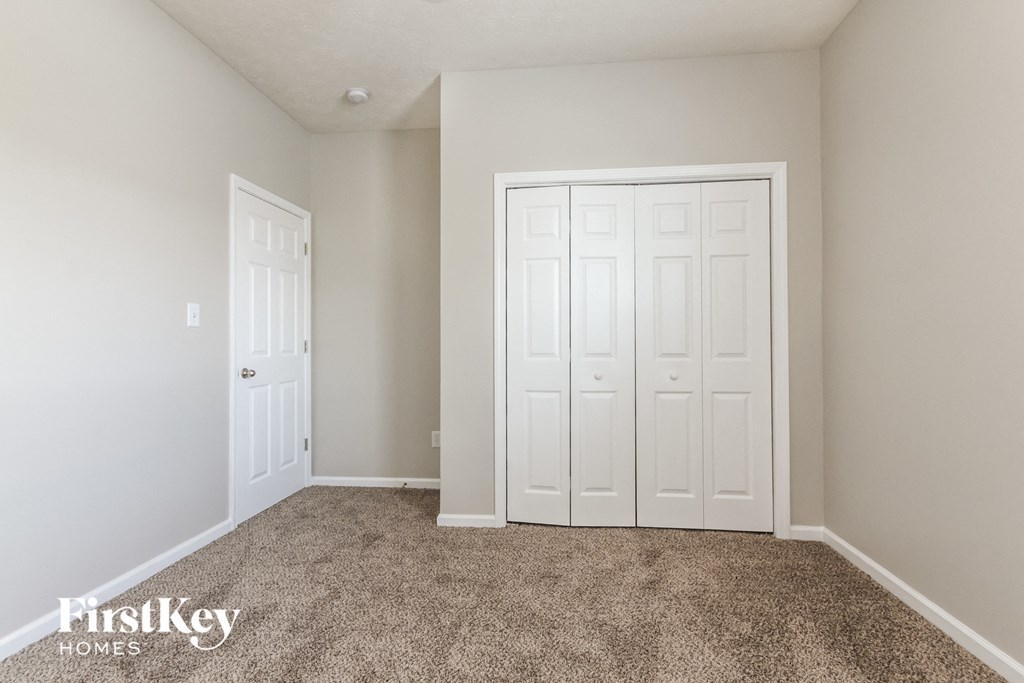 a bedroom with two closets and a carpeted floor