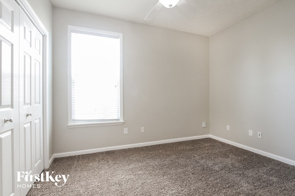 a bedroom with a carpeted floor and a window