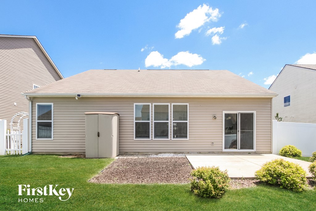 a beige house with a white door and a lawn