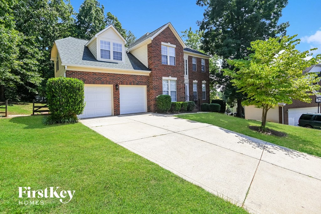 a brick house with a driveway and a white driveway