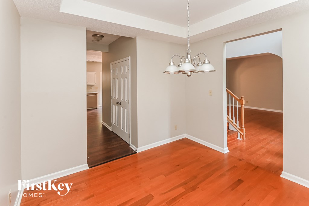 a renovated living room and dining room with wood flooring and a doorway to a