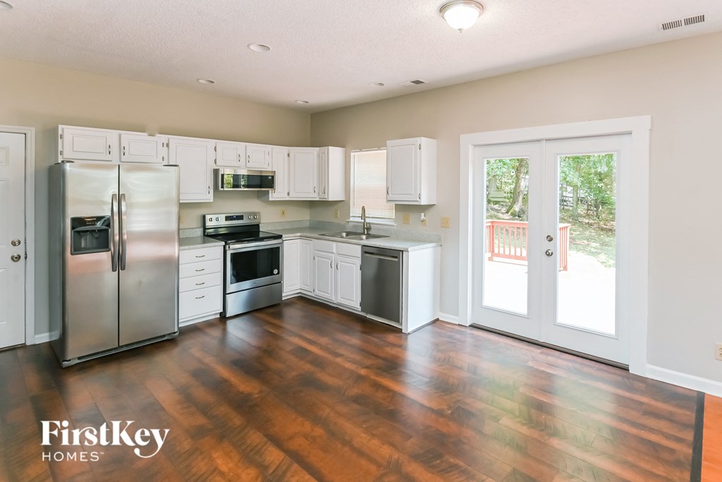 a kitchen with white cabinets and stainless steel appliances