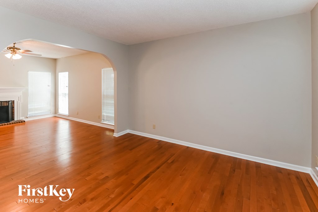 the living room and dining room with wood flooring and a fireplace