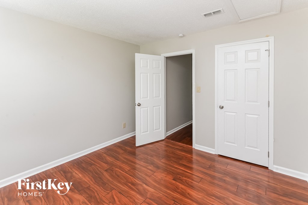 the living room of a house with wood floors and white doors