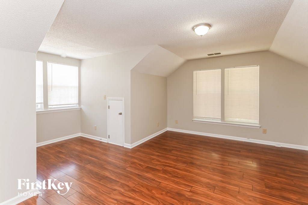 a living room with a hard wood floor and white walls