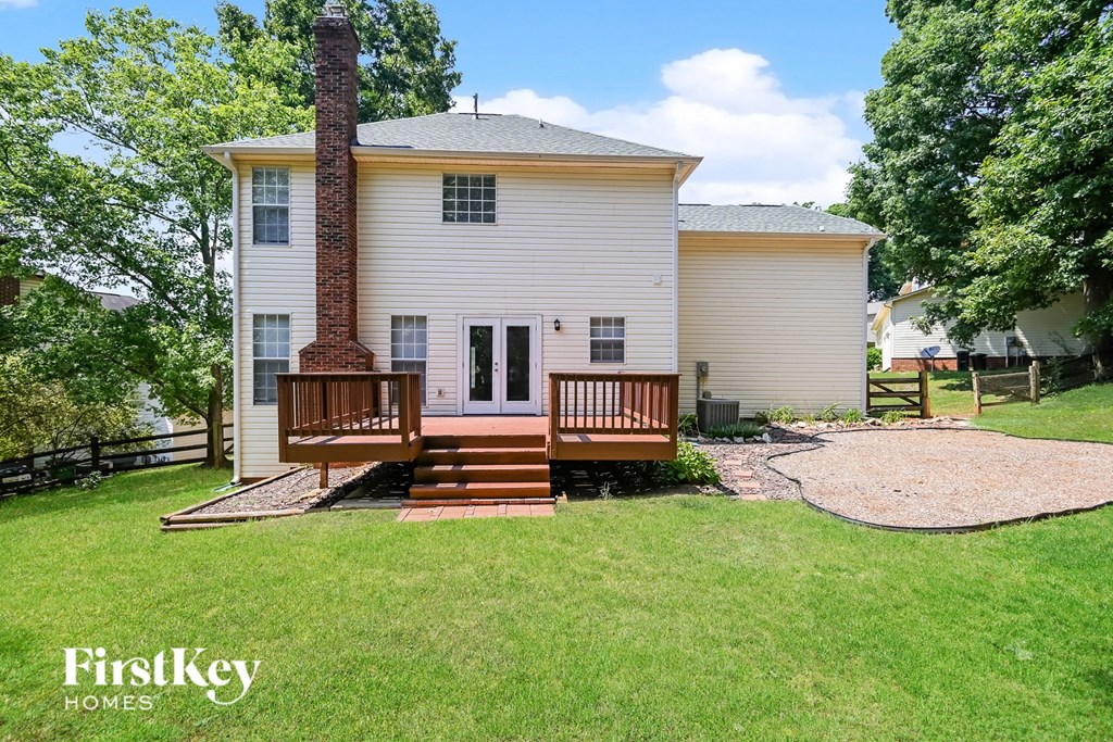 a small white house with a porch and a wood deck