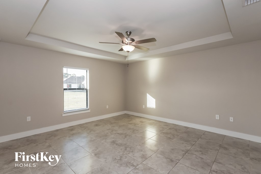 a living room with a ceiling fan and a tile floor