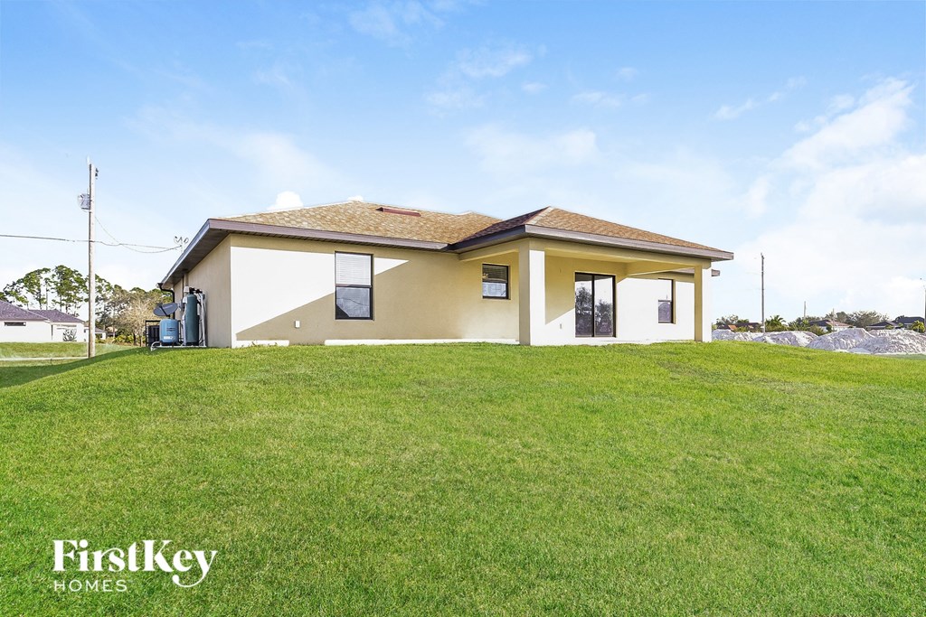 a small yellow house with a grassy yard