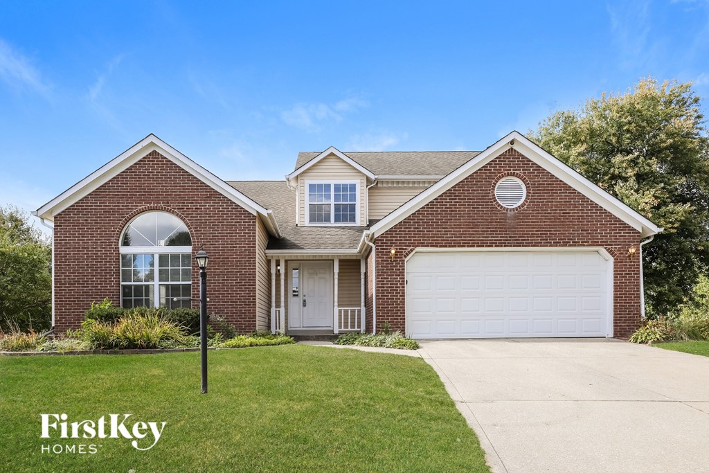 A brick house with a garage door and a window.