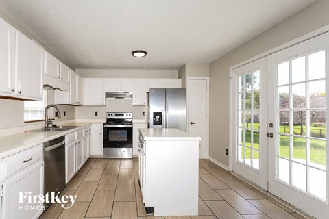 A kitchen with white cabinets and a refrigerator.