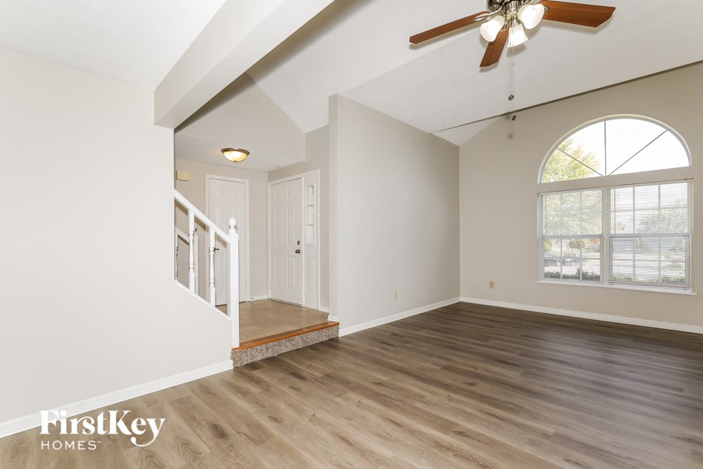 A room with a wooden floor and a ceiling fan.