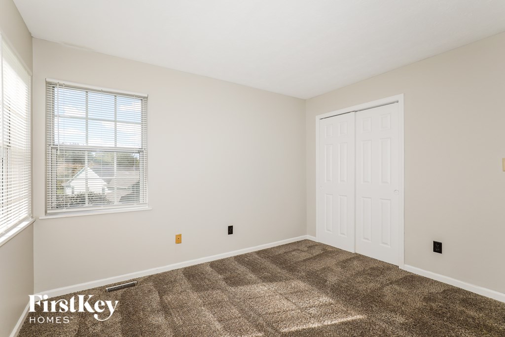 A room with a carpeted floor and a white door.