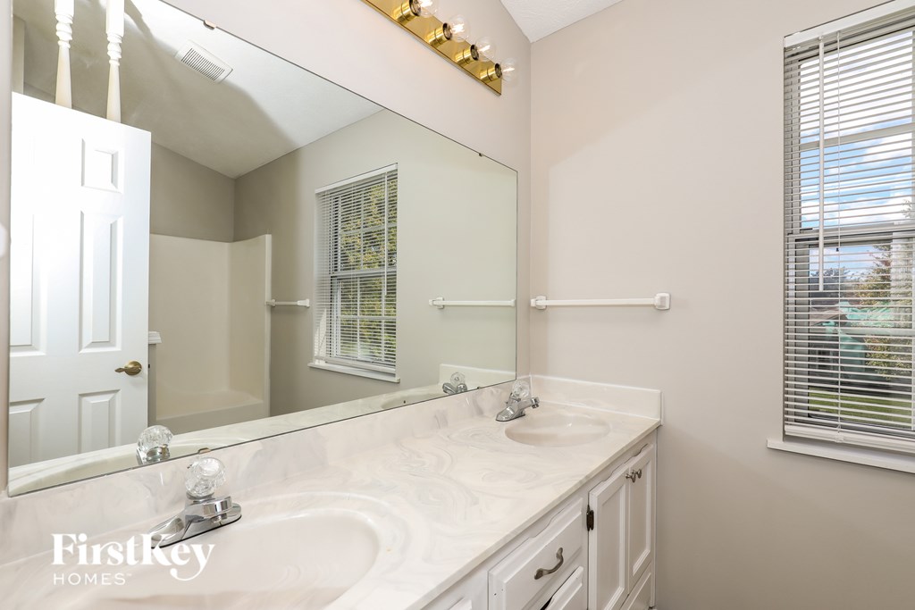 A bathroom with a large mirror and a white sink.