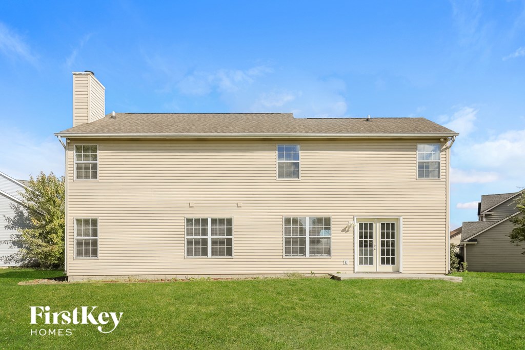 A house with a beige siding and a white door is for sale by FirstKey Homes.