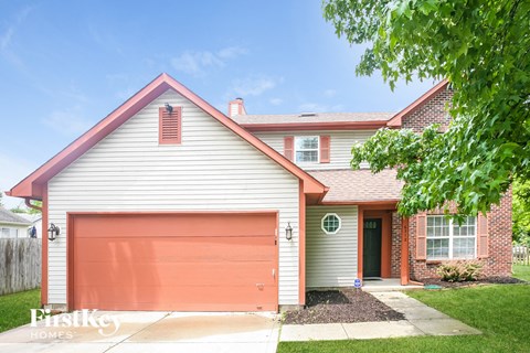 a white house with a red garage door