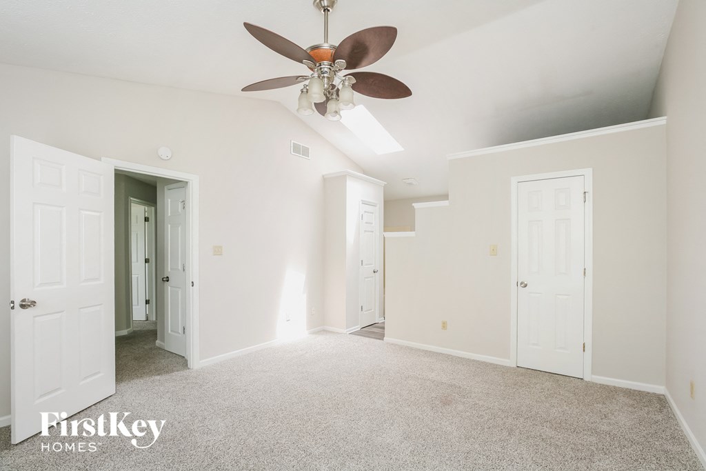 a living room with white walls and a ceiling fan