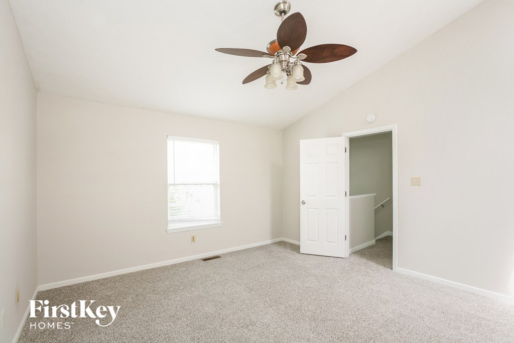 a bedroom with a ceiling fan and a closet
