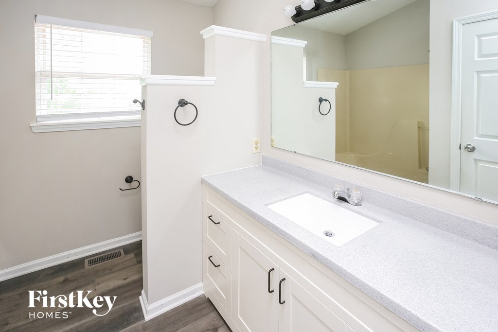 a white bathroom with a sink and a mirror