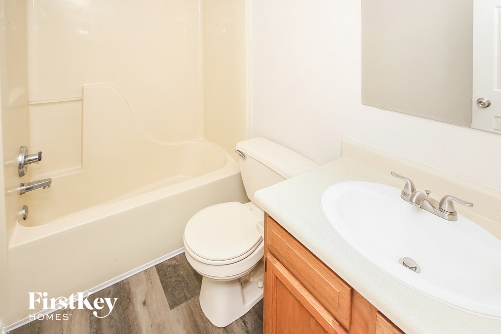 a bathroom with a toilet and a sink and a bath tub