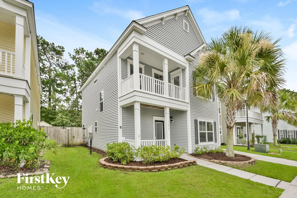 a white house with a balcony and a palm tree