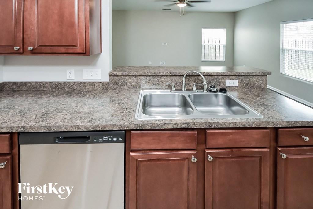 a kitchen with wood cabinets and granite counter tops and a stainless steel sink