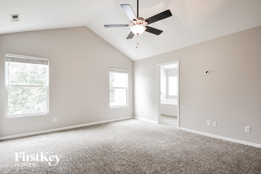 a bedroom with a ceiling fan and a carpeted floor