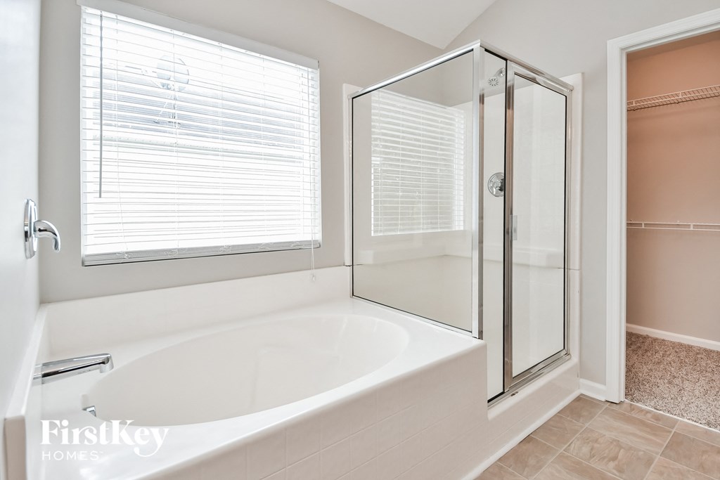 a white bathroom with a large tub and a shower