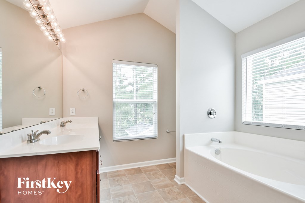 a bathroom with a tub and a sink and a mirror