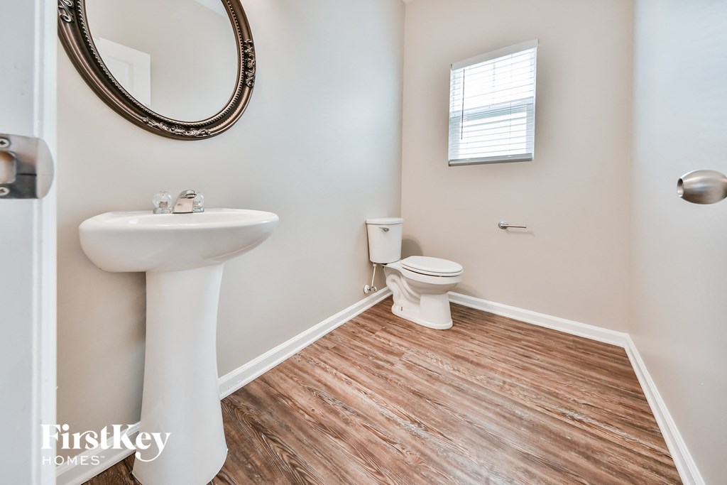 a bathroom with a toilet and a sink and a mirror