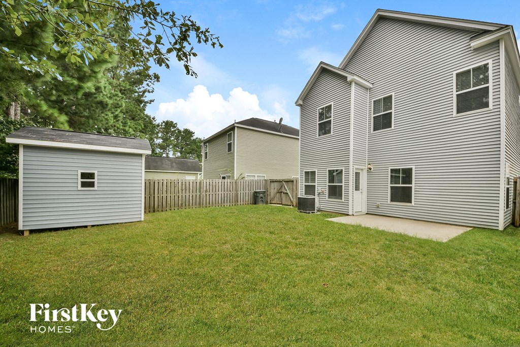 the backyard of a house with a yard and a white fence